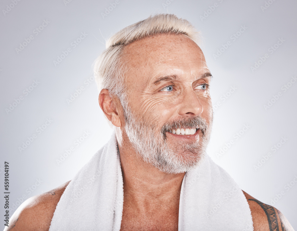 Obraz premium Senior man, beauty and skincare while grooming, happy and clean after a shower with a towel on a gray background. Face of a old male model with a smile for cosmetics, dermatology and healthy skin