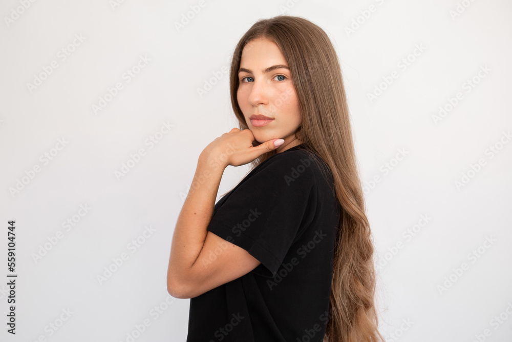 Portrait of serious young woman looking at camera over white background. Caucasian lady wearing black T-shirt posing with thoughtdul expression. Confidence concept Portrait of serious young woman looking at camera over white background. Caucasian lady wearing black T-shirt posing with thoughtdul expression. Confidence concept
