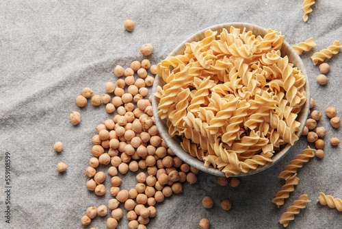 Chickpea bean fusilli pasta on a gray textile background.