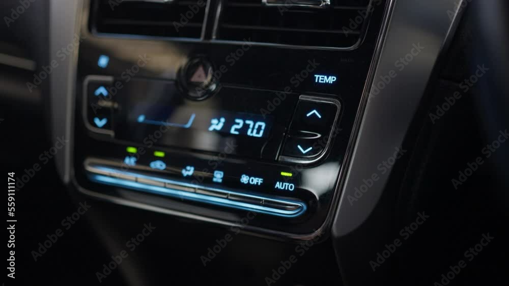 Close-up finger driver pushing the start air conditioner button in a smart car. automotive technology.