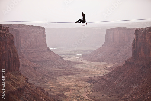 Andy Lewis working on a world record highline, three hundred and forty feet long, at the Fruit Bowl in Moab, Utah, USA. photo