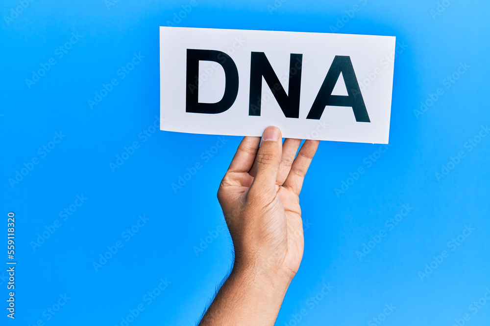Hand of caucasian man holding paper with dna word over isolated white background Hand of caucasian man holding paper with dna word over isolated white background