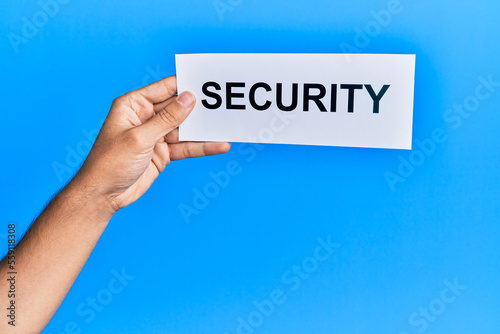 Hand of caucasian man holding paper with security word over isolated blue background