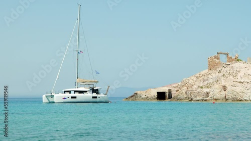 Catamaran anchored near Firopotamos coast, Milos Island, Greece photo