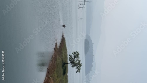 unedited iPhone footage of banasura sagar dam lake view with lonely tree, 4k 60 fps photo