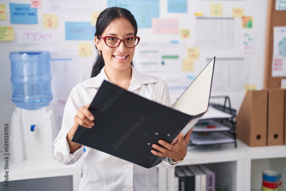 Young beautiful hispanic woman business worker reading document at office Young beautiful hispanic woman business worker reading document at office