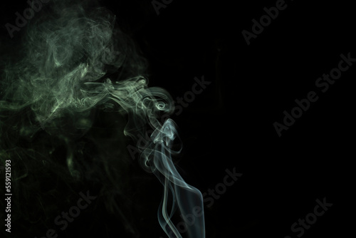 Fototapeta Naklejka Na Ścianę i Meble -  incense stick with green smoke against black background