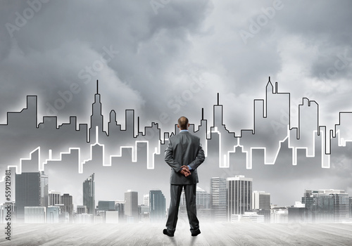 Motivation and inspiration concept with modern cityscape and businessman observing it