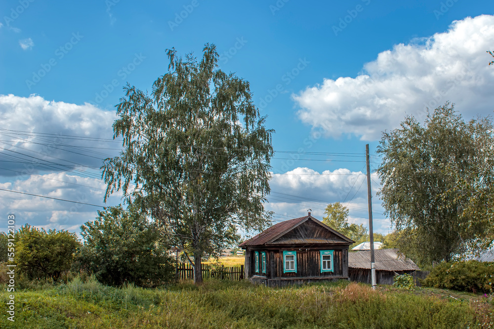 Wooden house in the Russian village in the summer day.