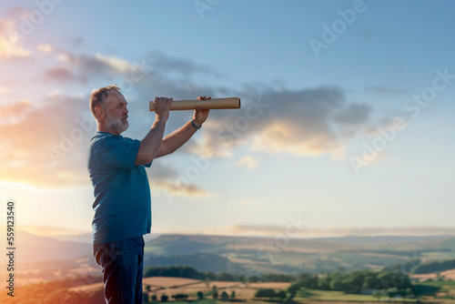 bearded retired man is looking for a destination on the map against the background of fields