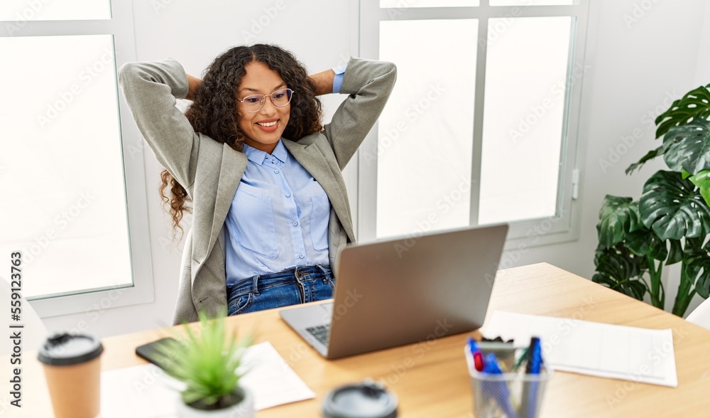 Young latin woman smiling confident relaxed with hands on head at office Young latin woman smiling confident relaxed with hands on head at office