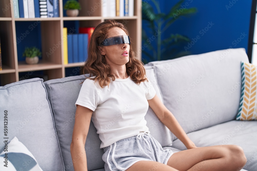 Young beautiful hispanic woman playing video game using virtual reality glasses at home Young beautiful hispanic woman playing video game using virtual reality glasses at home