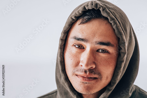 Close up horizontal portrait of asian man with hooded green sweatshirt photo