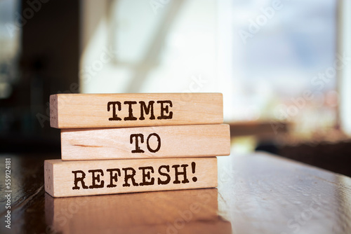 Wooden blocks form the words 'Time to refresh' on blur background.