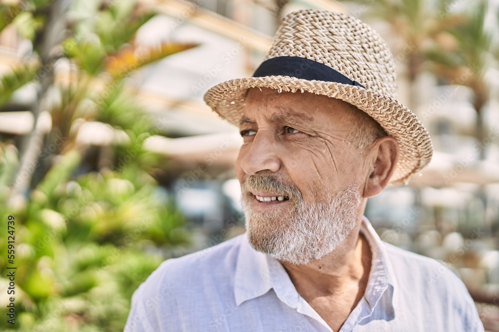 Senior man smiling confident wearing summer hat at street