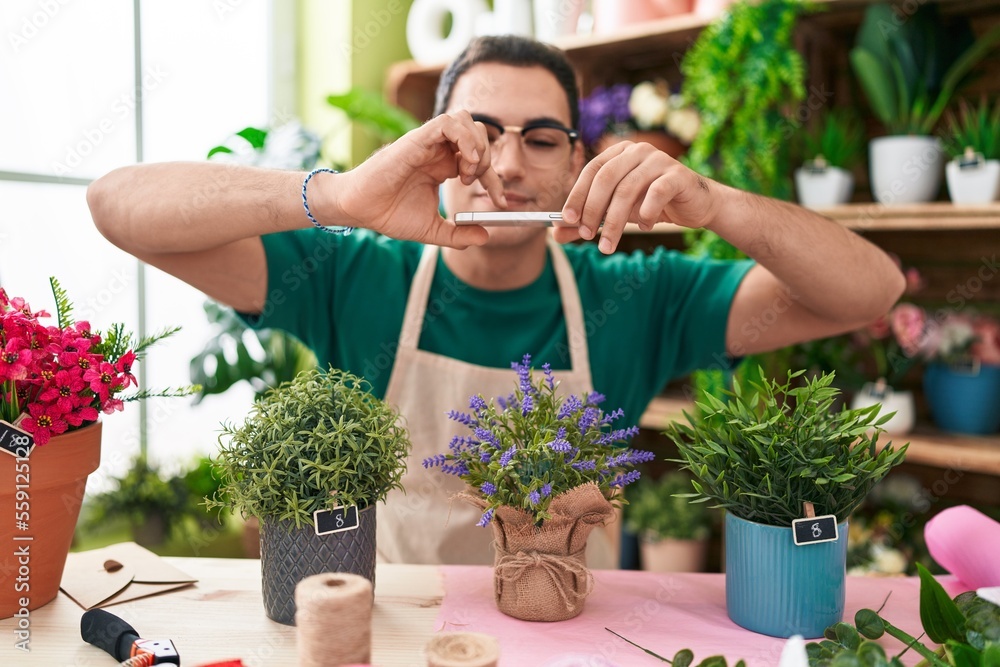 Young hispanic man florist make photo to lavender plant by smartphone at flower shop Young hispanic man florist make photo to lavender plant by smartphone at flower shop