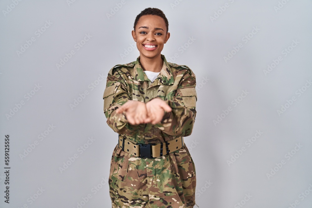 Beautiful african american woman wearing camouflage army uniform smiling with hands palms together receiving or giving gesture. hold and protection