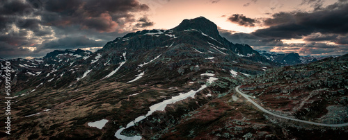 Mountain landscape with summit of Bitihorn in Jotunheimen National Park, with road leading through the park, during sunset in Norway photo