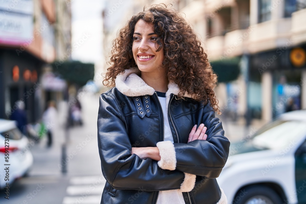 Young hispanic woman smiling confident standing with arms crossed gesture at street