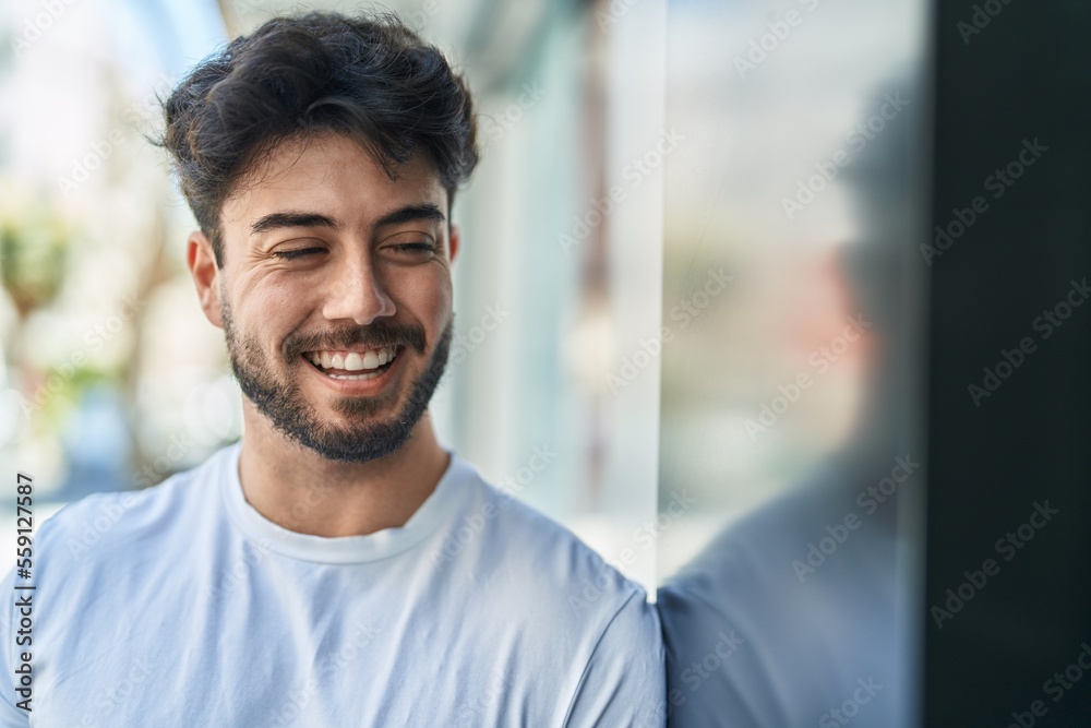 Young hispanic man smiling confident looking to the side at street Young hispanic man smiling confident looking to the side at street