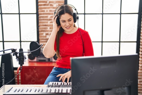 Young woman dj playing music session at music studio
