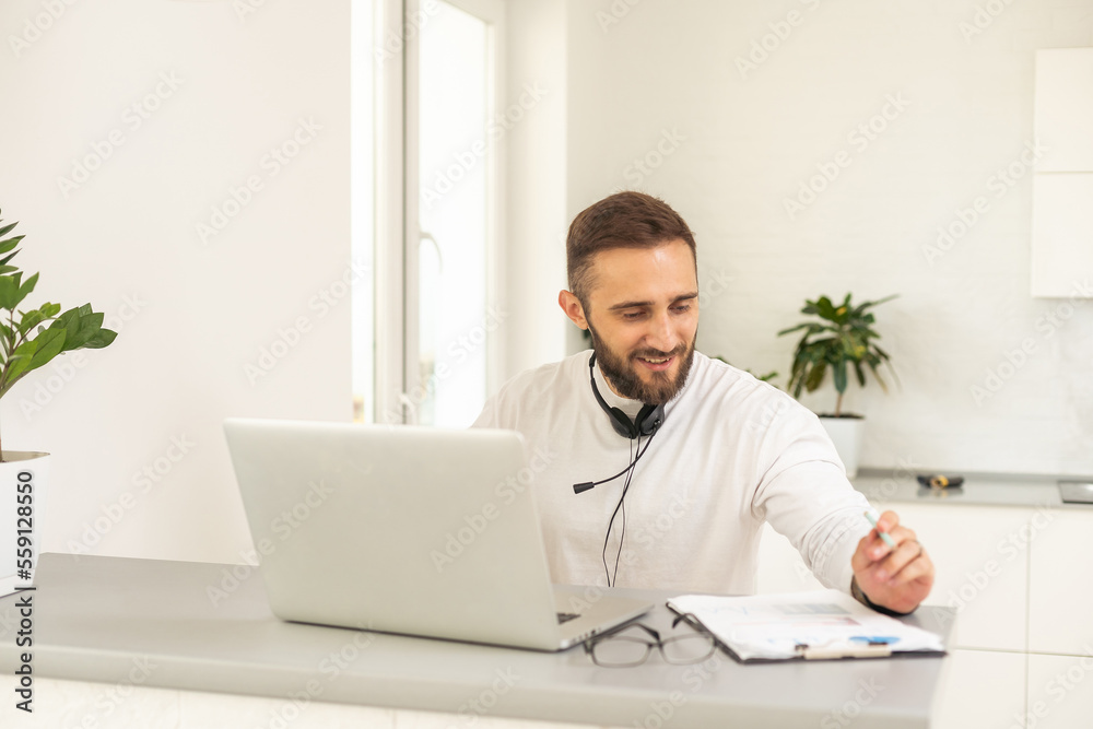 Bearded hipster style adult man working writing, freelance home sitting male typing on keyboard