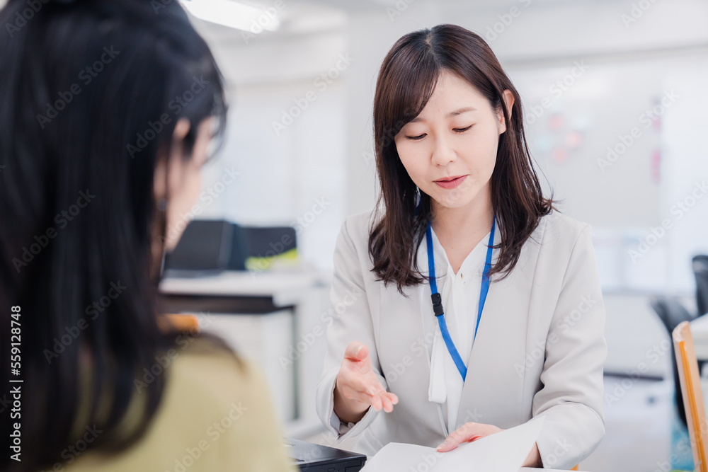 窓口で対応をする女性 窓口で対応をする女性