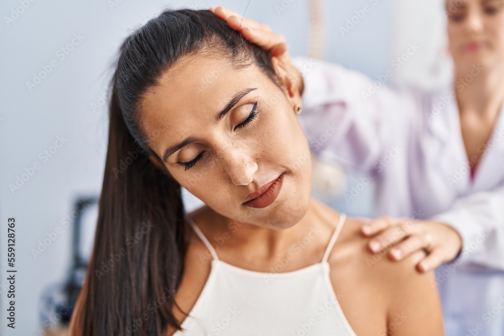 Young hispanic woman having rehab session at physiotherapy clinic