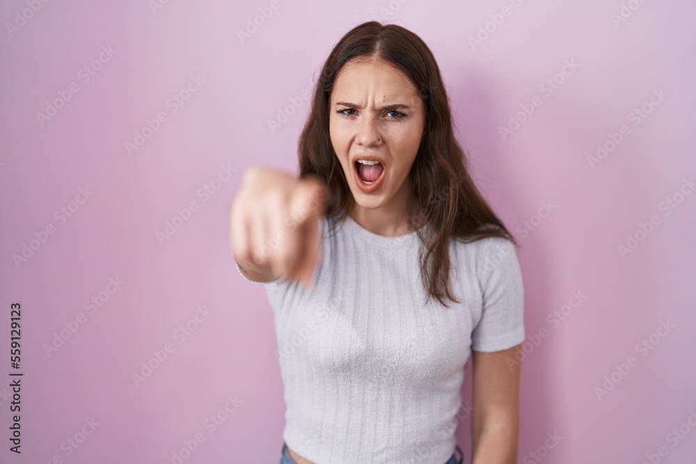 Young hispanic girl standing over pink background pointing displeased and frustrated to the camera, angry and furious with you Young hispanic girl standing over pink background pointing displeased and frustrated to the camera, angry and furious with you