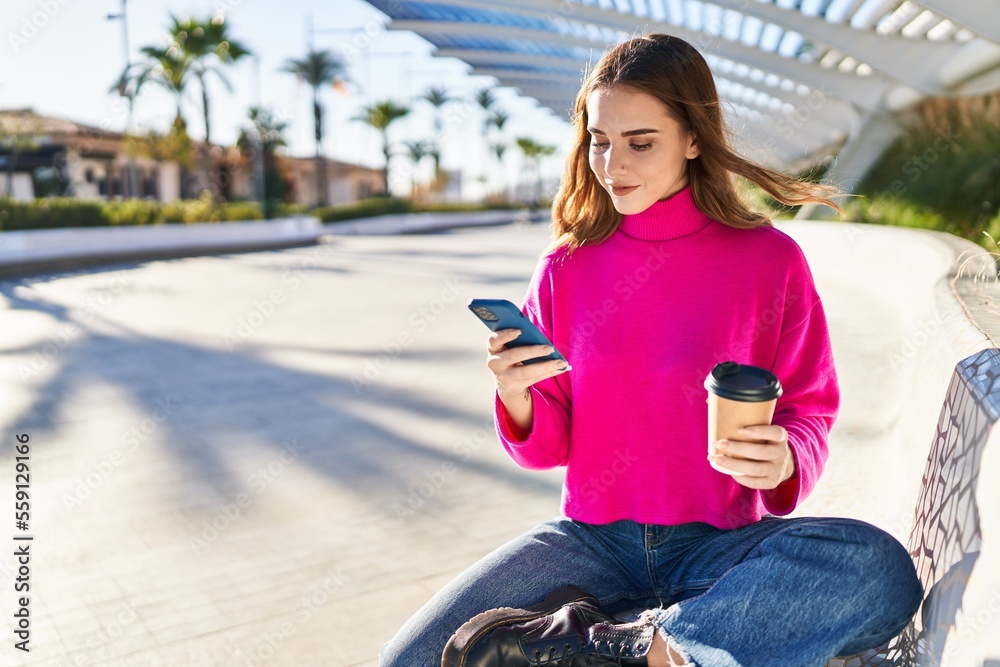 Young woman using smartphone drinking coffee at park
