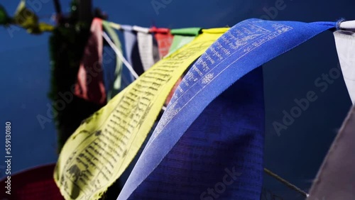 slow motion macro shot sacred religious multicolored prayer flags moving in the wind showing a bhuddist prayer incantation common in hill stations in Himachal Pradesh India