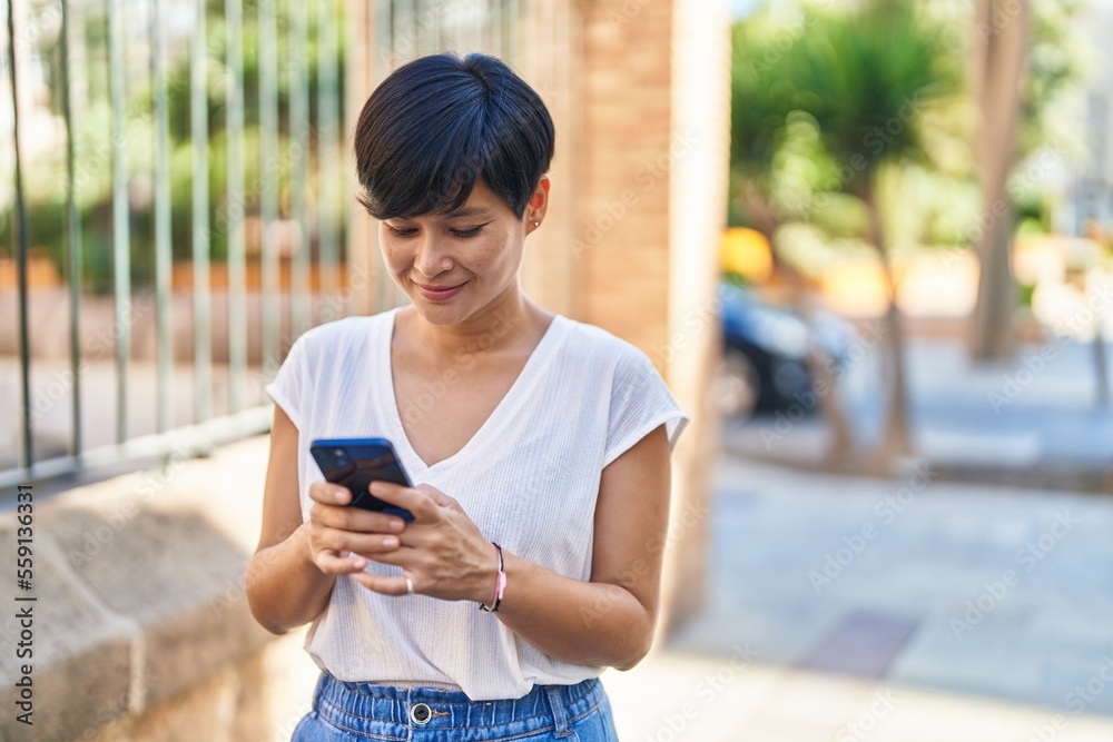 © Krakenimages.com - Middle age chinese woman smiling confident using smartphone at street