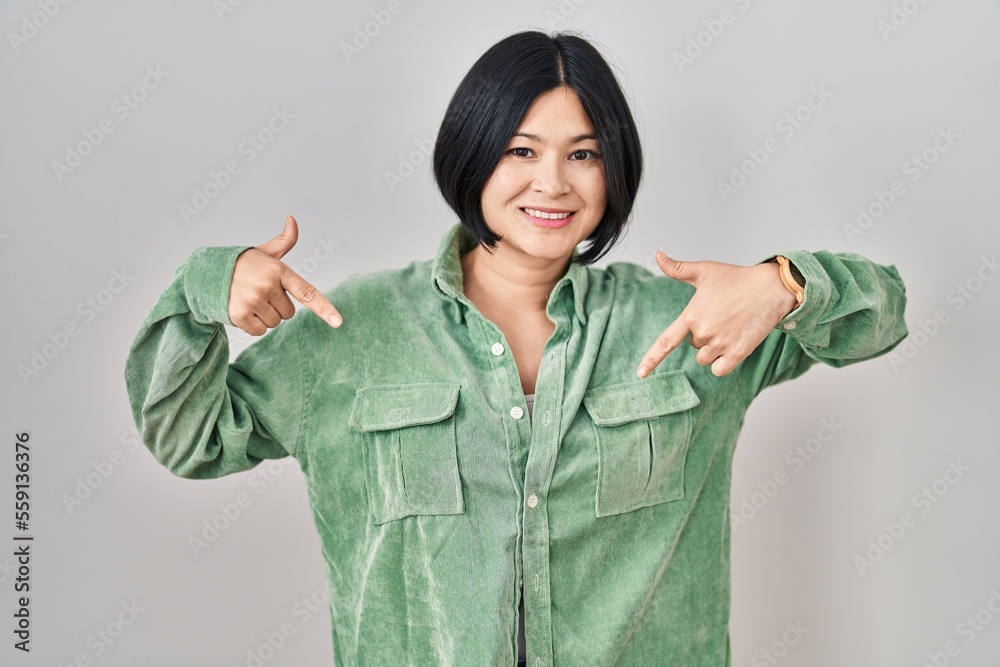 Young asian woman standing over white background looking confident with smile on face, pointing oneself with fingers proud and happy. Young asian woman standing over white background looking confident with smile on face, pointing oneself with fingers proud and happy.