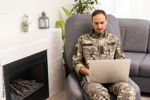 Surveillance and control of opposing information concept, Soldier in camouflage uniform working on laptop for Information Operation