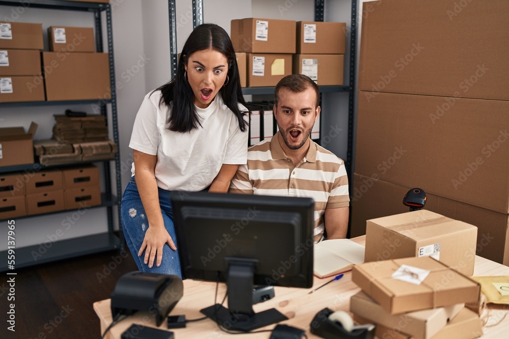 Young hispanic people working at small business ecommerce scared and amazed with open mouth for surprise, disbelief face Young hispanic people working at small business ecommerce scared and amazed with open mouth for surprise, disbelief face