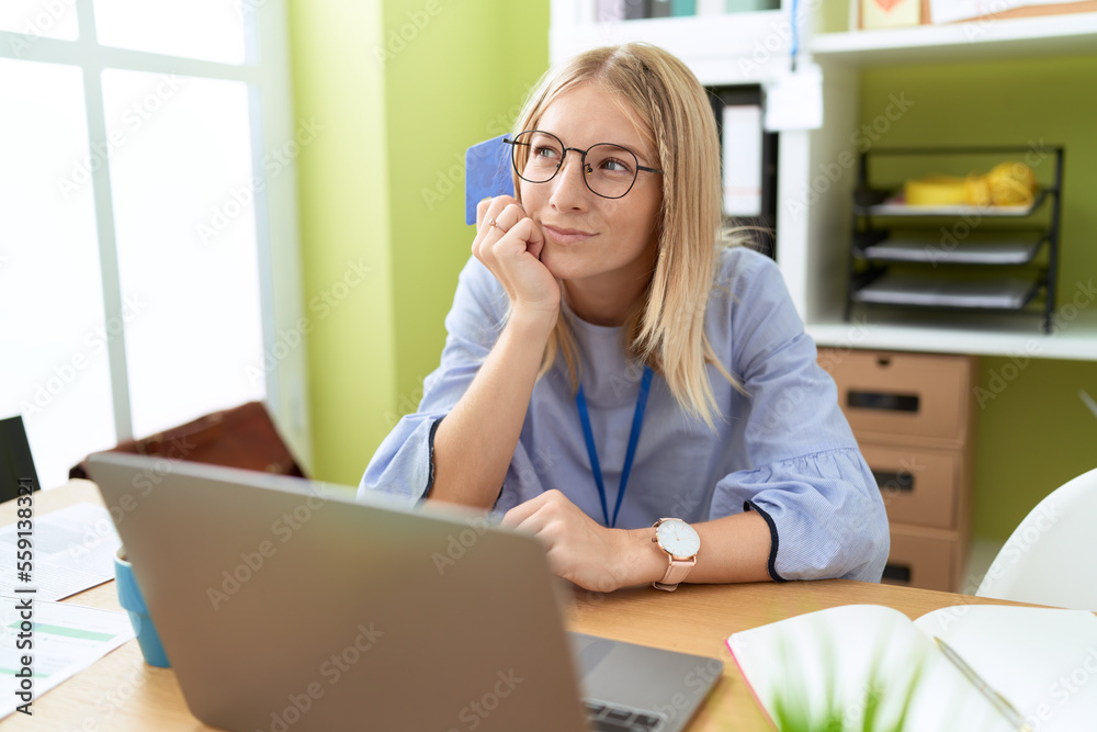 Obraz premium Young blonde woman business worker using laptop and credit card at office