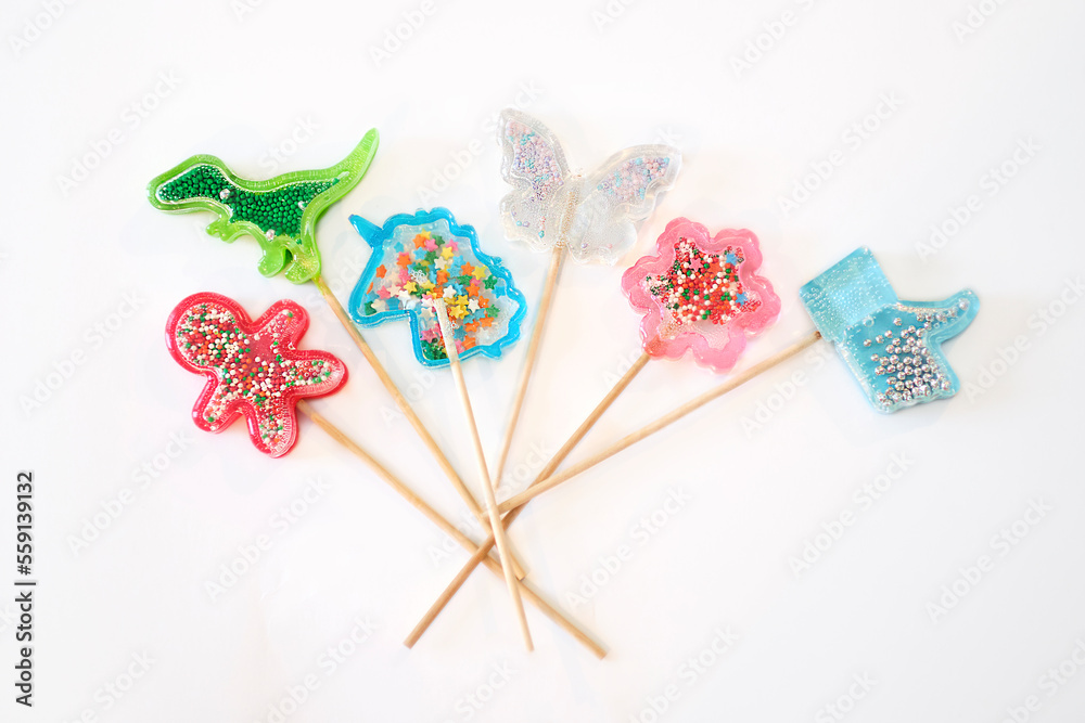Set of colorful lollipops isolated on white background. beautiful lollipops in the shape of dinosaur, unicorn, flower, and butterfly