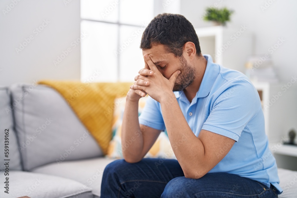 Young man stressed sitting on sofa at home Young man stressed sitting on sofa at home