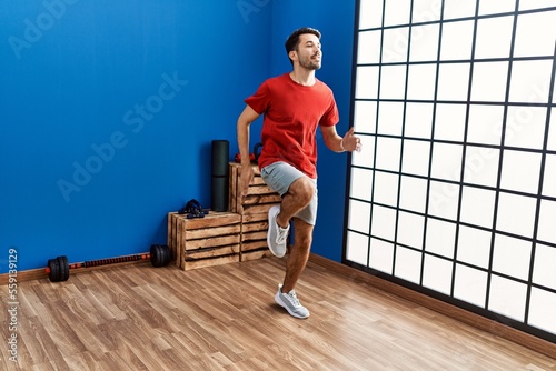 Young hispanic man smiling confident training at sport center