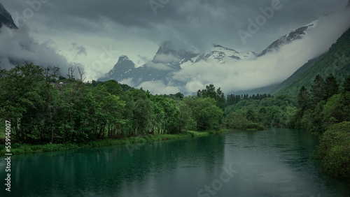 River landscape of Romsdalen with snowy mountains Troll Wall in Norway  moody rain weather with dark clouds