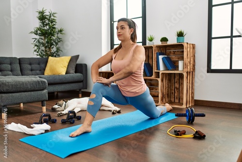 Young woman stretching at home