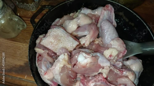 Cooking chopped chicken with an ax in a pan