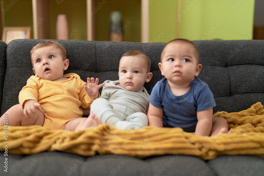 Group of toddlers sitting on sofa at home Group of toddlers sitting on sofa at home