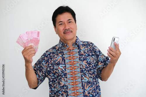 Man holding cellphone and some cash money smiling happily photo
