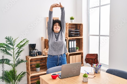 Young middle east woman business worker stretching arms at office