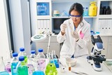 Young chinese woman wearing scientist uniform working at laboratory