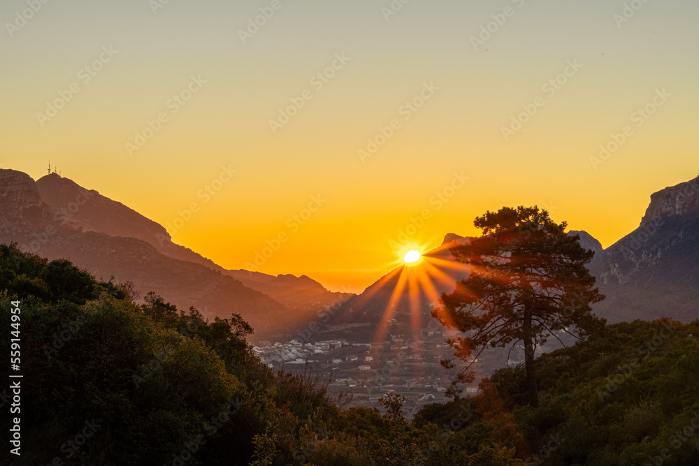 Obraz premium Landscape, the sun rises between the mountains, forming beautiful rays of light, landscape of trees and mountains, clear sky