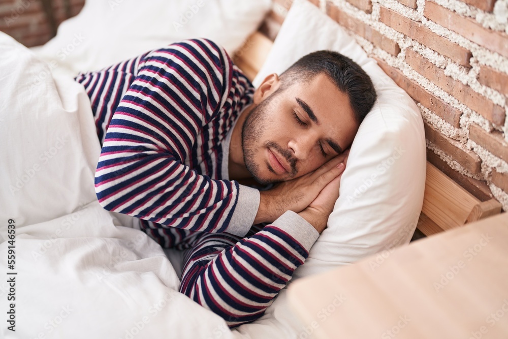 Young hispanic man lying on bed sleeping at bedroom Young hispanic man lying on bed sleeping at bedroom