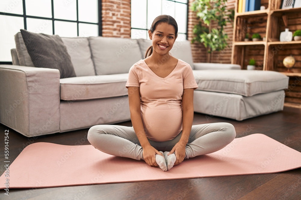 Young latin woman pregnant smiling confident stretching at home Young latin woman pregnant smiling confident stretching at home