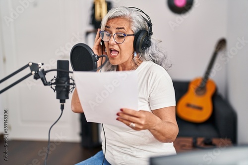 Konstfotografi Middle age woman musician singing song at music studio